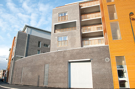 Boligbygg med murte fasader og oransje kledning